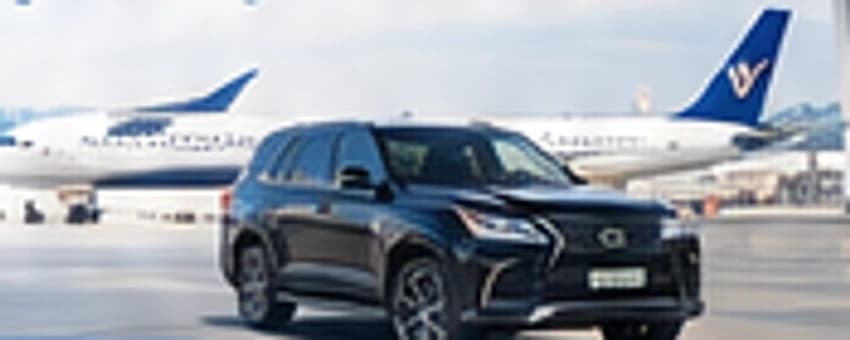 A black SUV waiting on the apron beside aircraft at a Lagos airport terminal