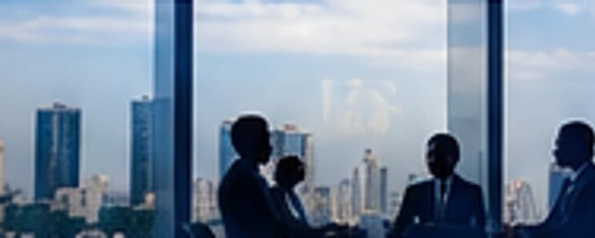 Executives meeting in a boardroom above the Lagos skyline